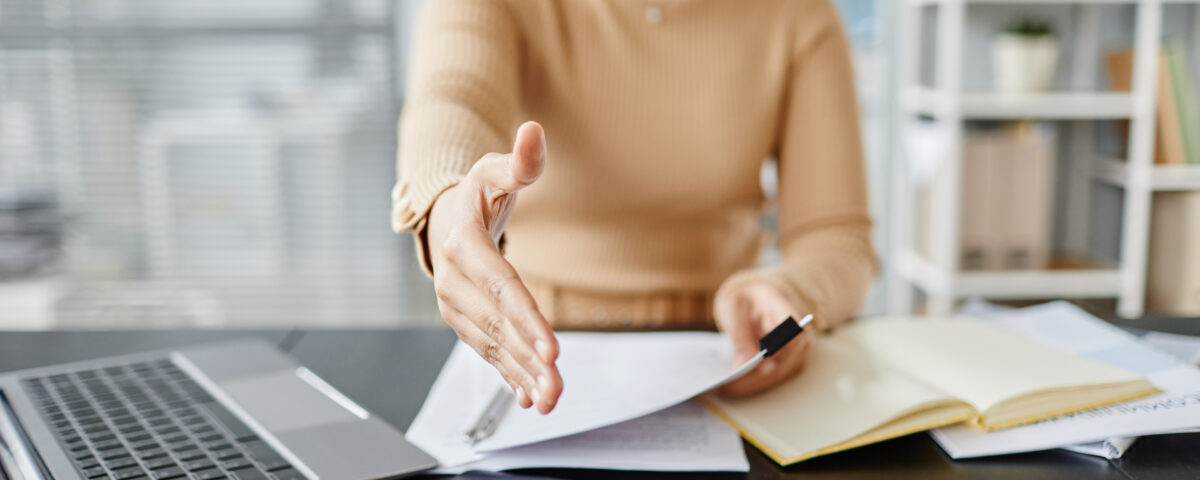 Close up of female HR recruiter stretching hand for greeting to camera in job interview, copy space
