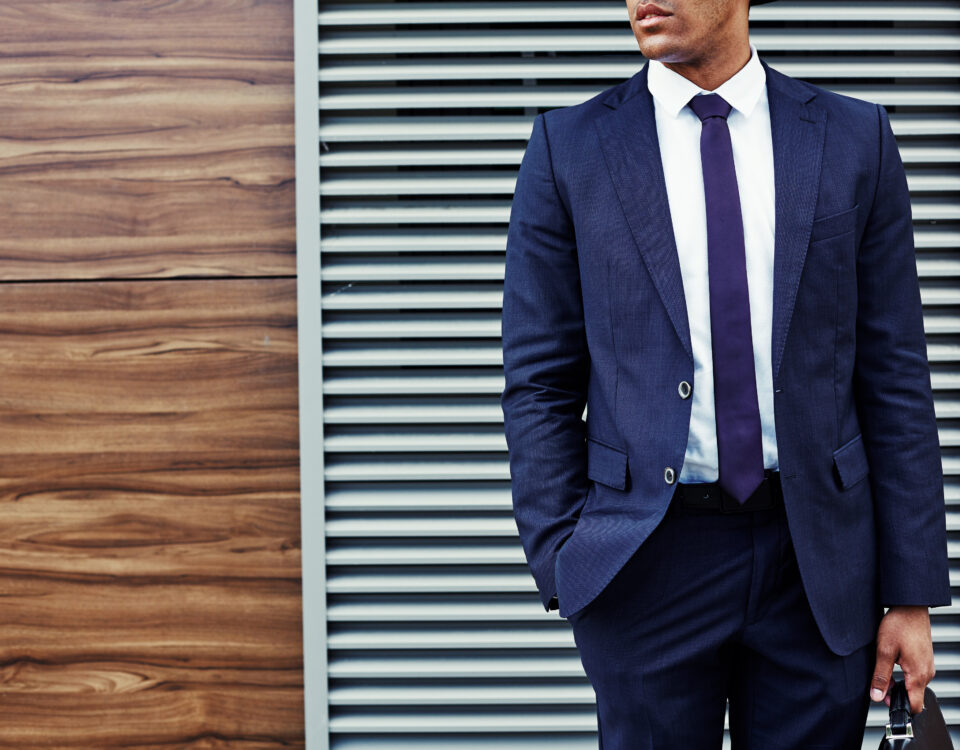 Well-dressed young businessman standing at the wall